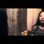 Mujer mirándose en el espejo de un baño desgastado; ¡Descubre qué se puede plantar en año bisiesto y maximiza tu cosecha!