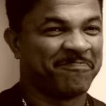 Retrato en primer plano de un hombre sonriente en tono sepia; ¡Descubre los secretos para plantar tus propias frutas de la pasión en casa!